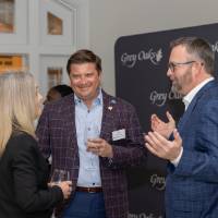 Jim Overbeck standing and talking with two other event guests